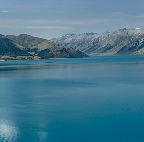 blue lake near snow covered mountain during daytime